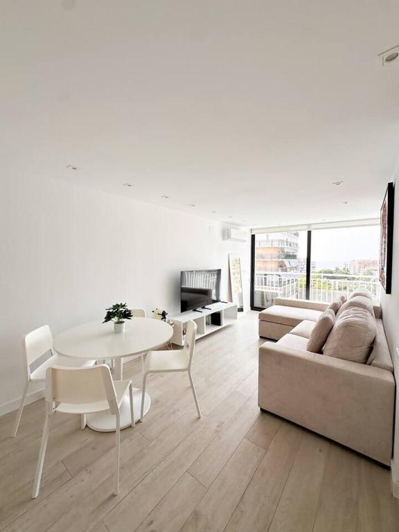 a white living room with a table and a couch at Rincón Albufereta Piscina, Sierra y Mar in Alicante