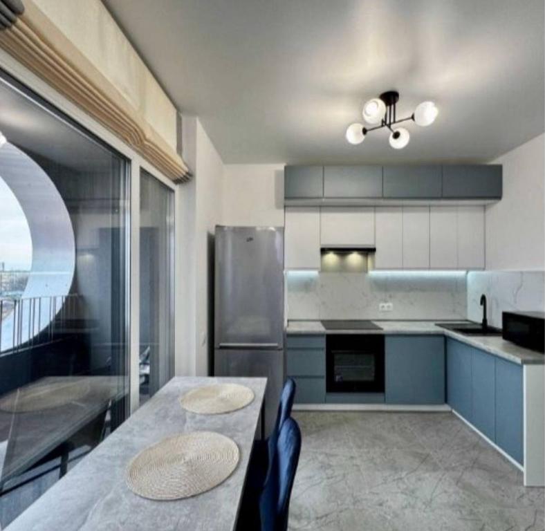 eine Küche mit blauen Schränken und einem Tisch mit Stühlen in der Unterkunft La familia ЖК республіка 195 in Kiew