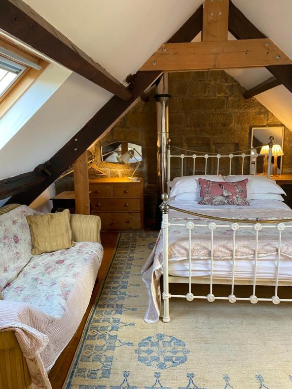 a bedroom with a bed and a couch in a attic at Daffodil in Whitby