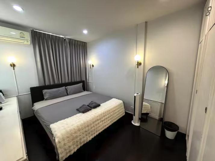 une chambre avec un grand lit et un miroir dans l'établissement 4BR 12PAX 7min walk to Samitivej Sukhumvit Hospital, à Klong Toi