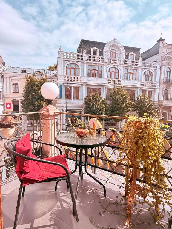 a table and chairs on a balcony with a building at Boutique Hotel Gold Tbilisi in Tbilisi City