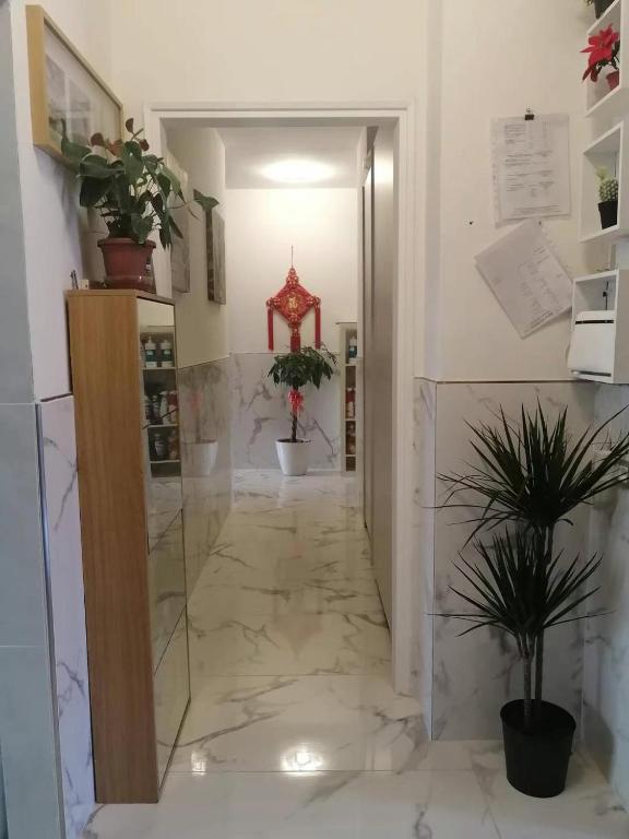 a lobby with a marble floor and a hallway with potted plants at YiJia - Locazione Turistica in Padova