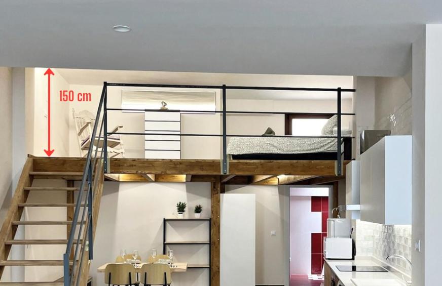 a loft bed in a small room with a kitchen at Encanto Rural en Requena in Requena