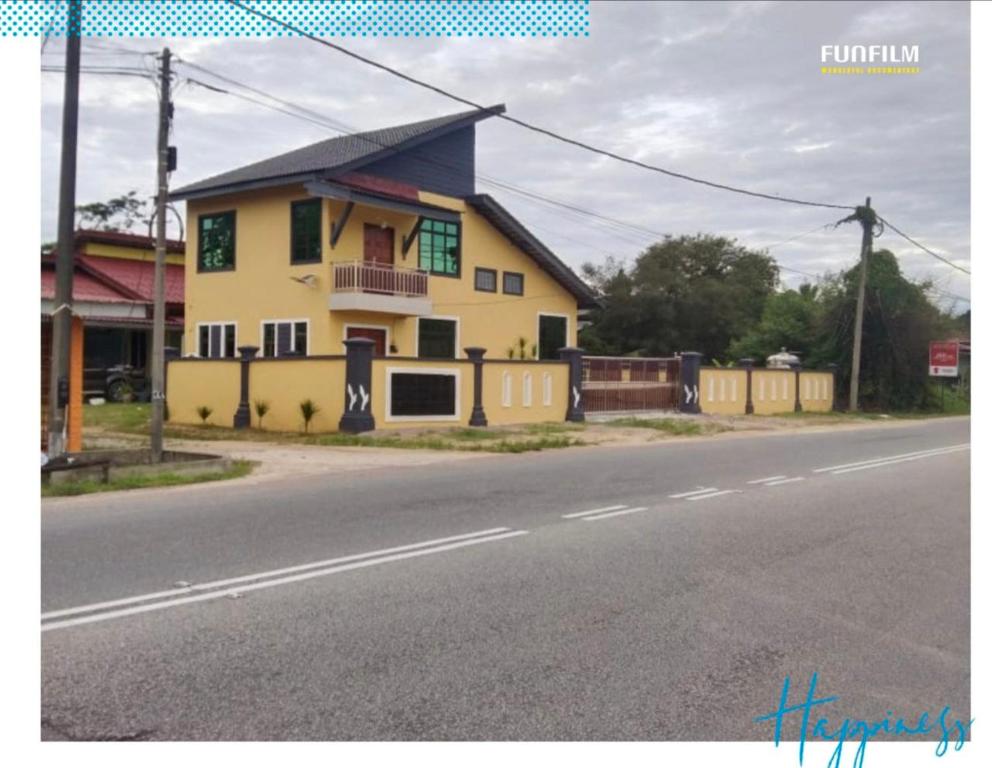a yellow house on the side of a road at Fahim Homestay Pasir Mas in Pasir Mas
