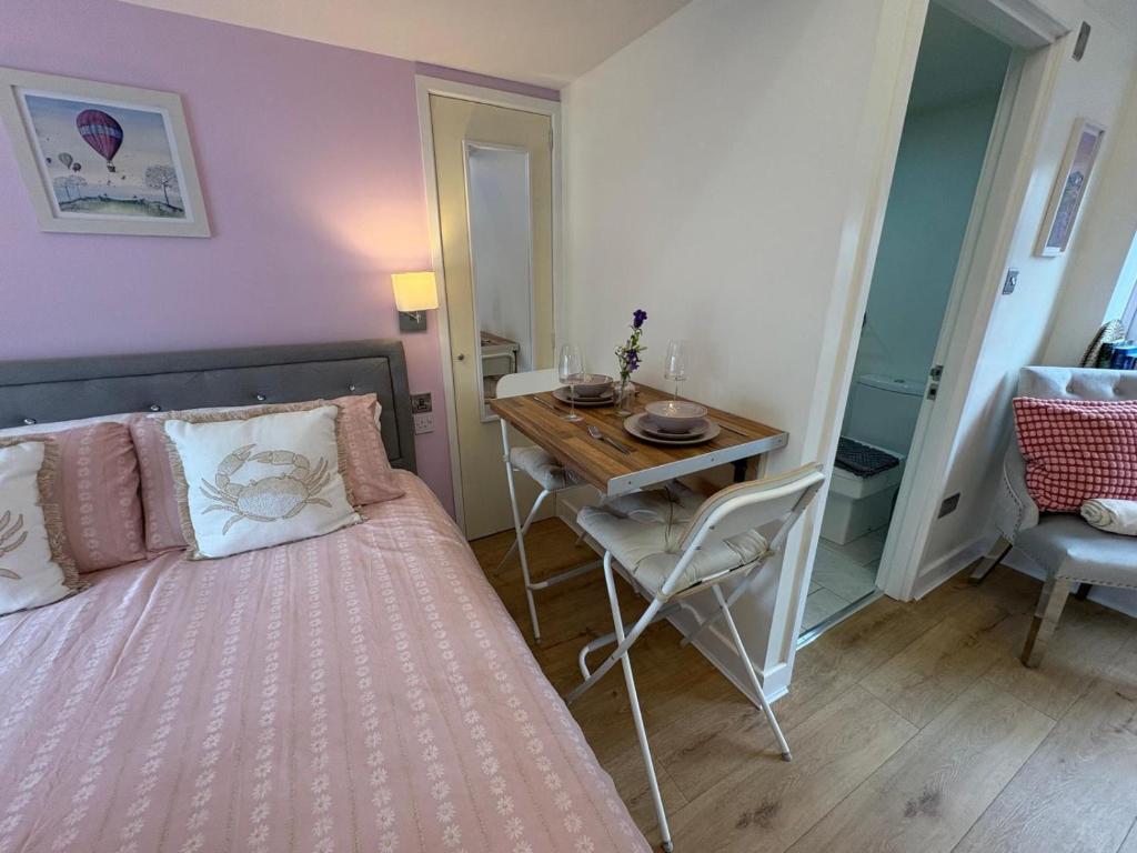 a bedroom with a bed and a table and a desk at Robyns Retreat - Cosy Hideaway Perfect To Explore in Brynsiencyn