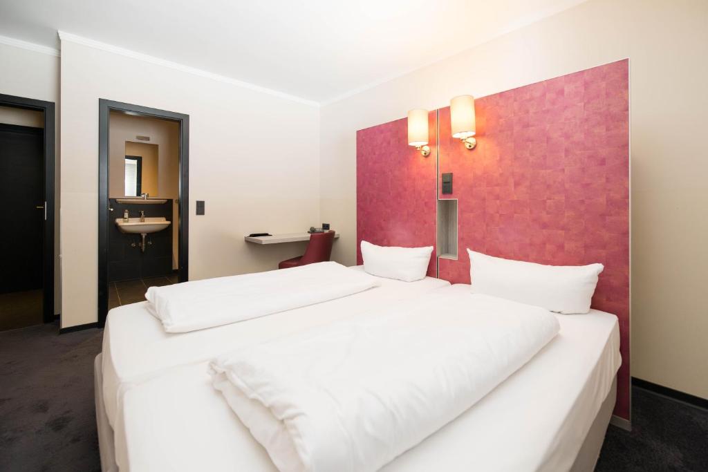 Postel nebo postele na pokoji v ubytování Hotel Topas Frankfurt City