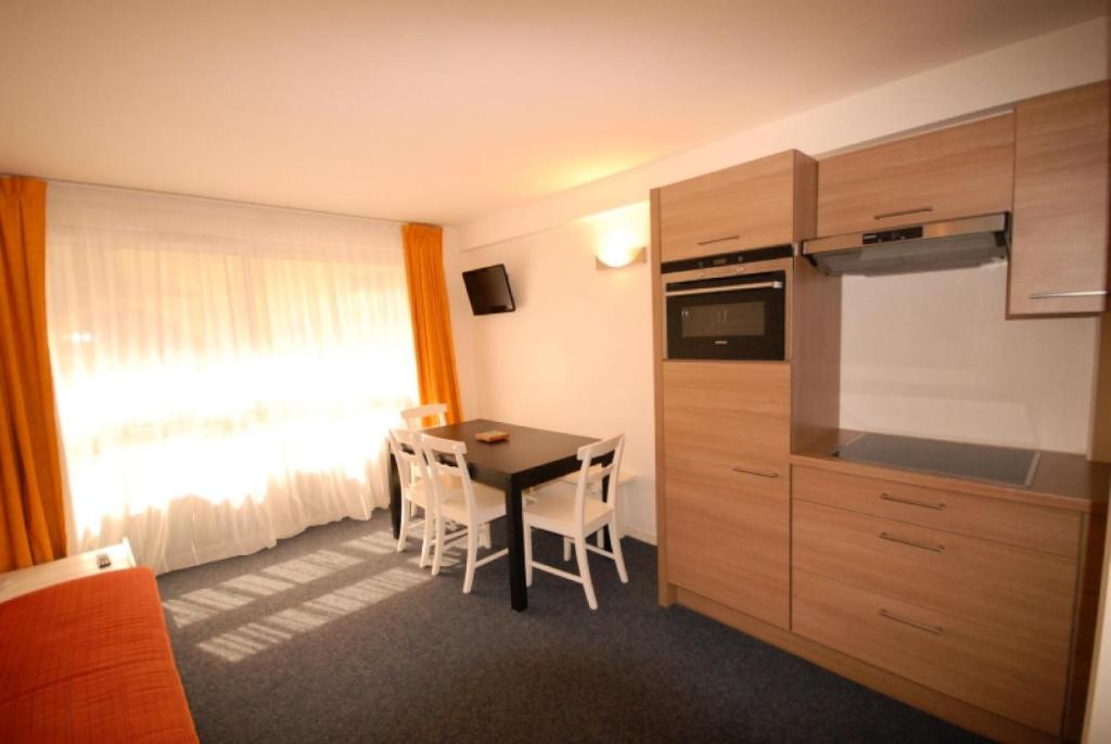 a room with a kitchen and a table with chairs at Résidence Marmottes - 2 Pièces pour 8 Personnes MAE-6013 in Gourette