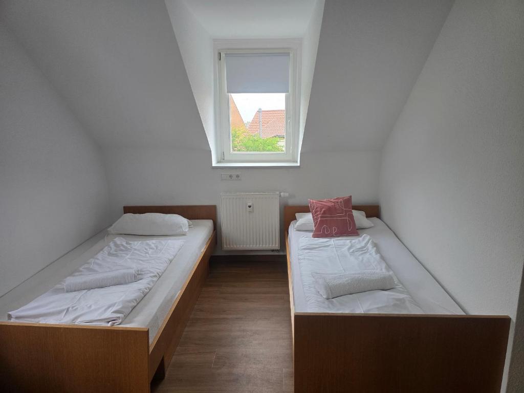 two beds in a small room with a window at Ferienwohnung Hohenstaufen in Göppingen