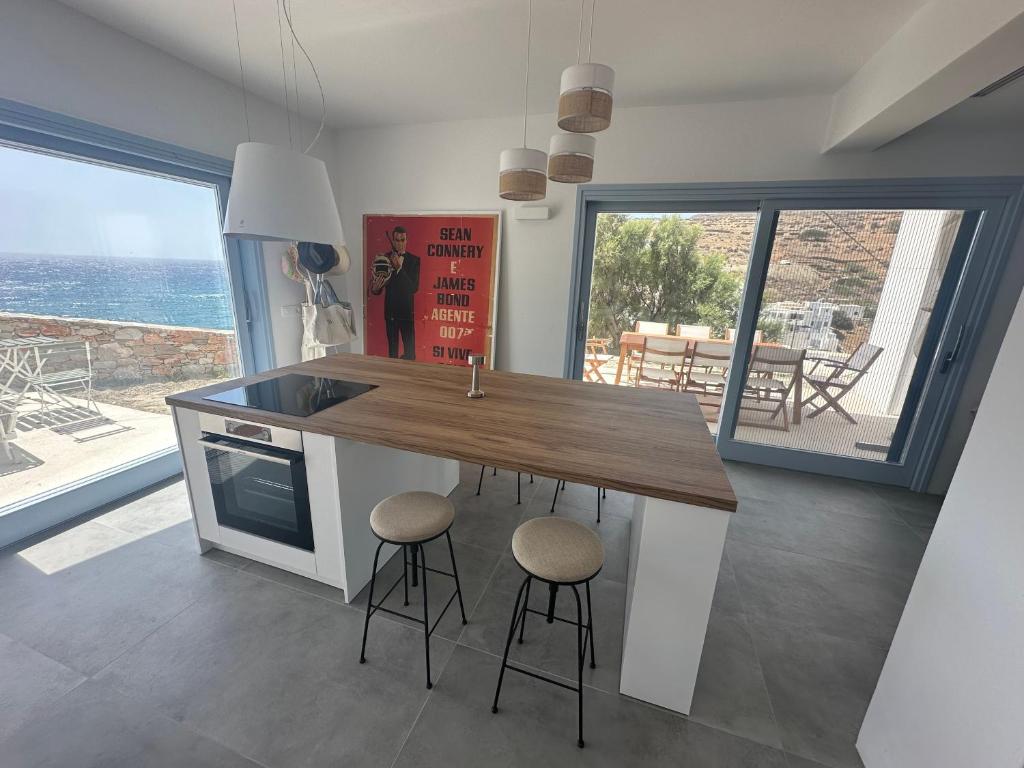 a kitchen with a island with stools and a counter top at CASA GIGLIO Folegandros in Agali