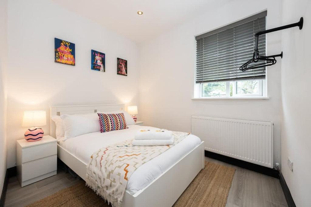 a white bedroom with a bed and a window at The Didsbury Loft in Manchester