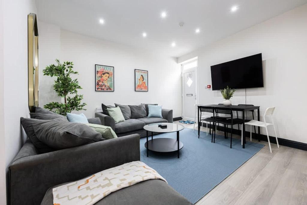 een woonkamer met een bank en een tafel bij The Didsbury Loft in Manchester
