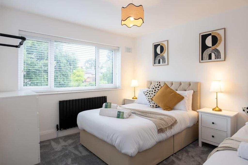 a bedroom with two beds and two windows at The Wilmslow House Free Parking - Close to Airport in Alderley Edge