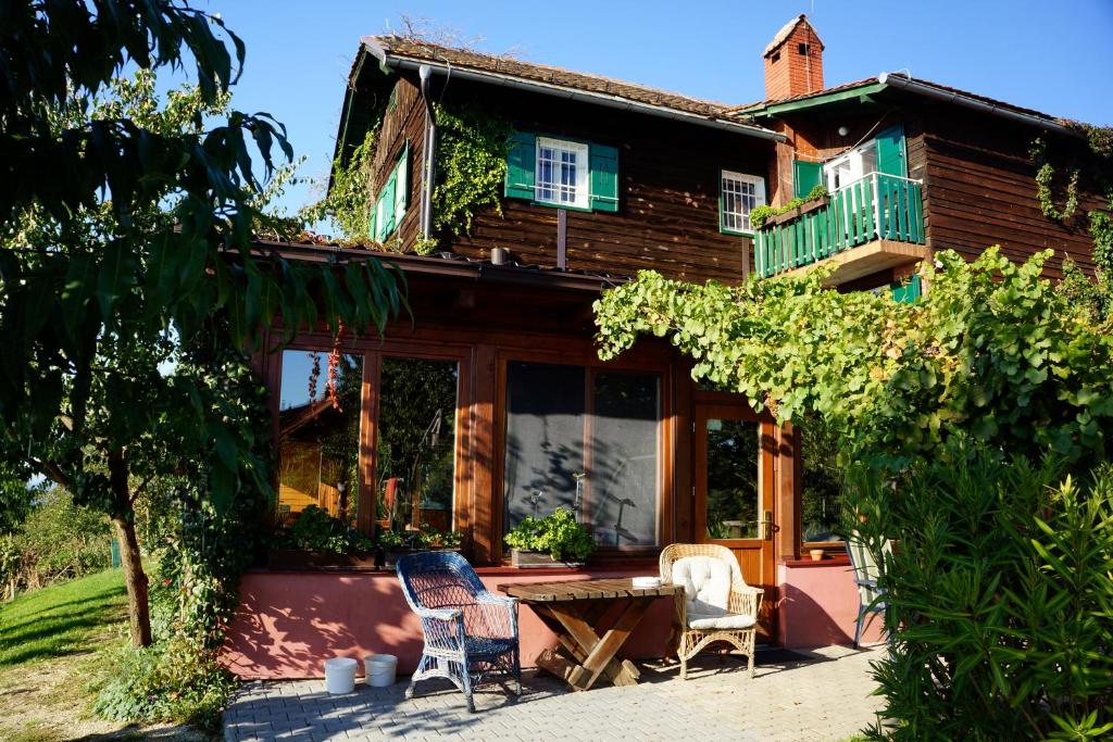 ein Haus mit zwei Stühlen und einem Tisch davor in der Unterkunft Agroturism Jures in Ljutomer