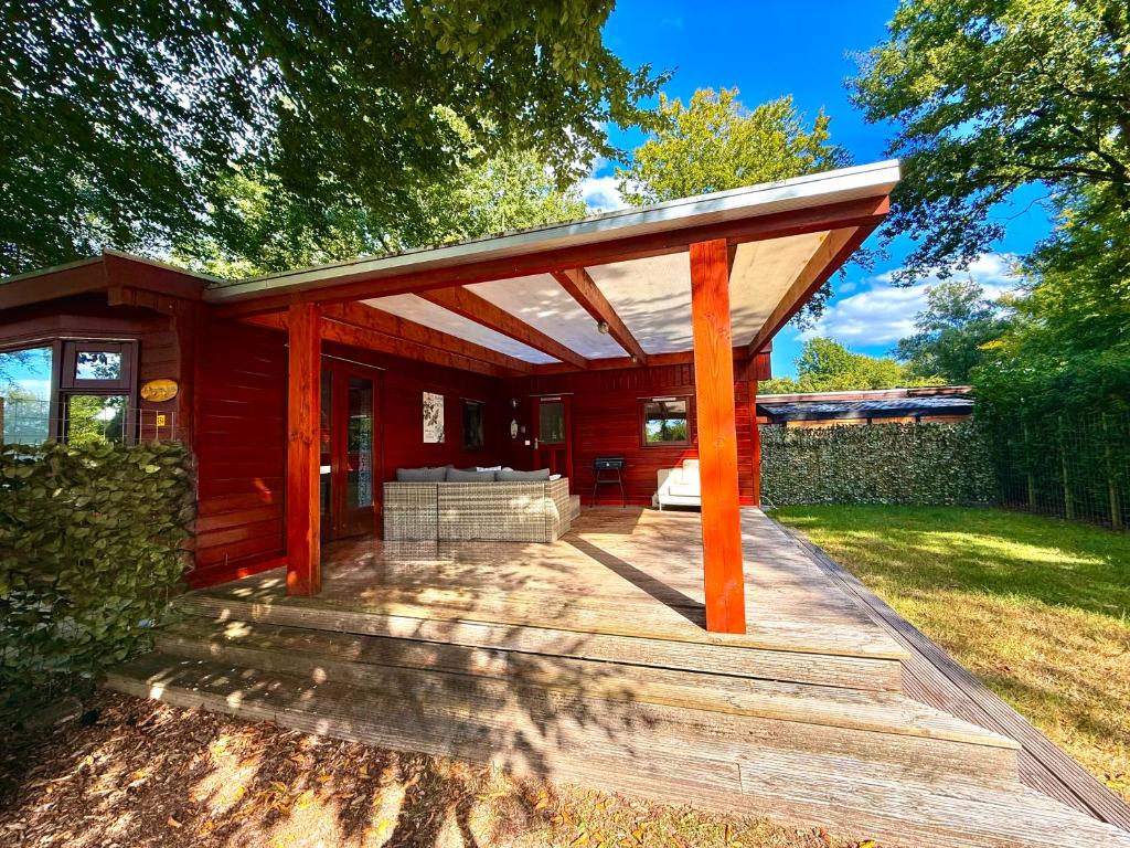 a covered porch of a red house at Ermmoon Cottage in Erm