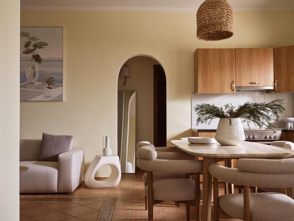 eine Küche und ein Wohnzimmer mit Tisch und Stühlen in der Unterkunft Aristotle Luxury Apartment with Sea View in Argassi
