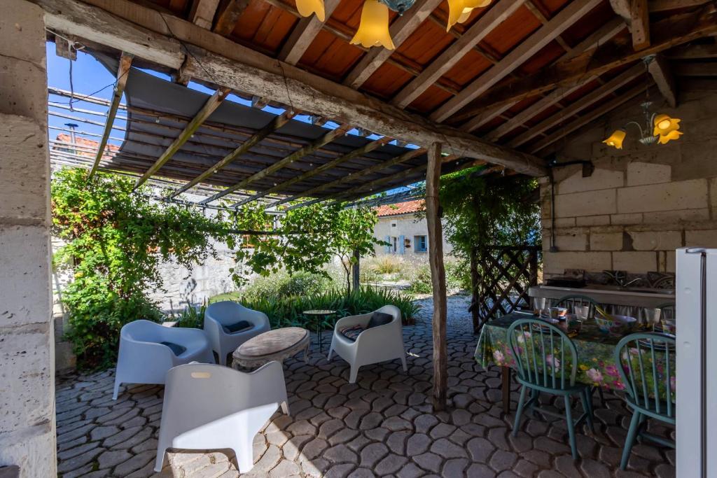 a patio with chairs and tables under a pergola at Les Nenuphars - Dordogne, Riberac in Saint-Martial-Viveyrol