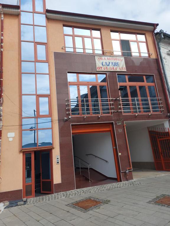 a building with a garage and a balcony at Apartament Adriano in Turda