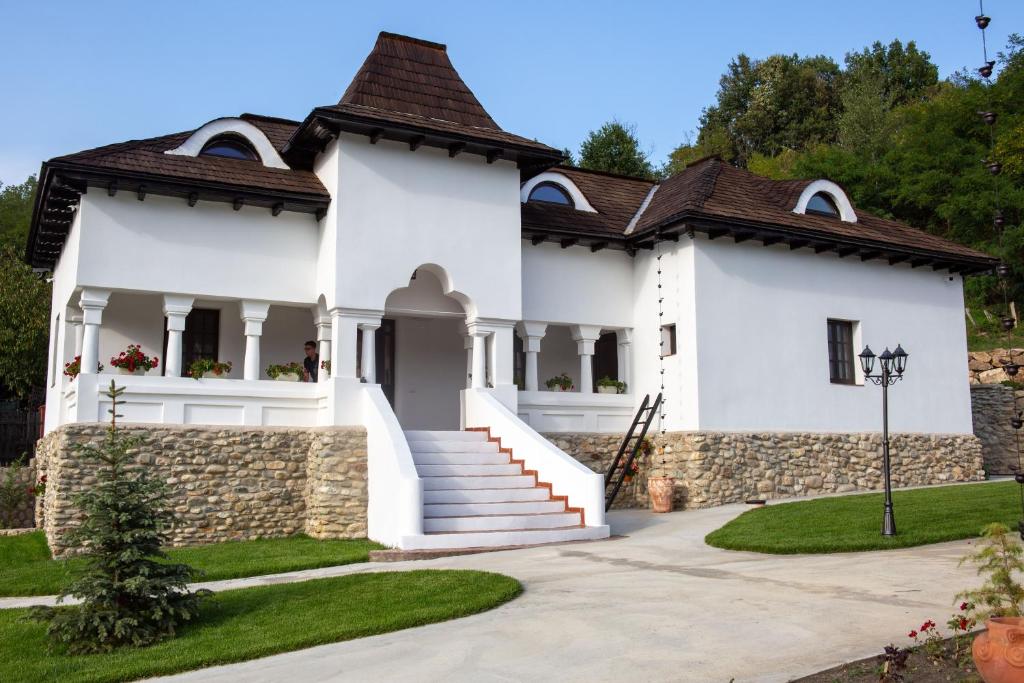 a white house with a brown roof at Odaile Brancovenesti -Maldaresti in Măldăreşti