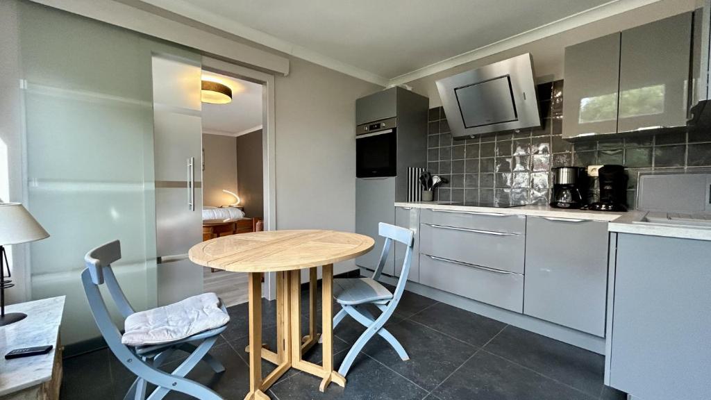 una piccola cucina con tavolo e sedie in legno di Studio Bauwens – Le Crotoy, hyper-centre a Le Crotoy