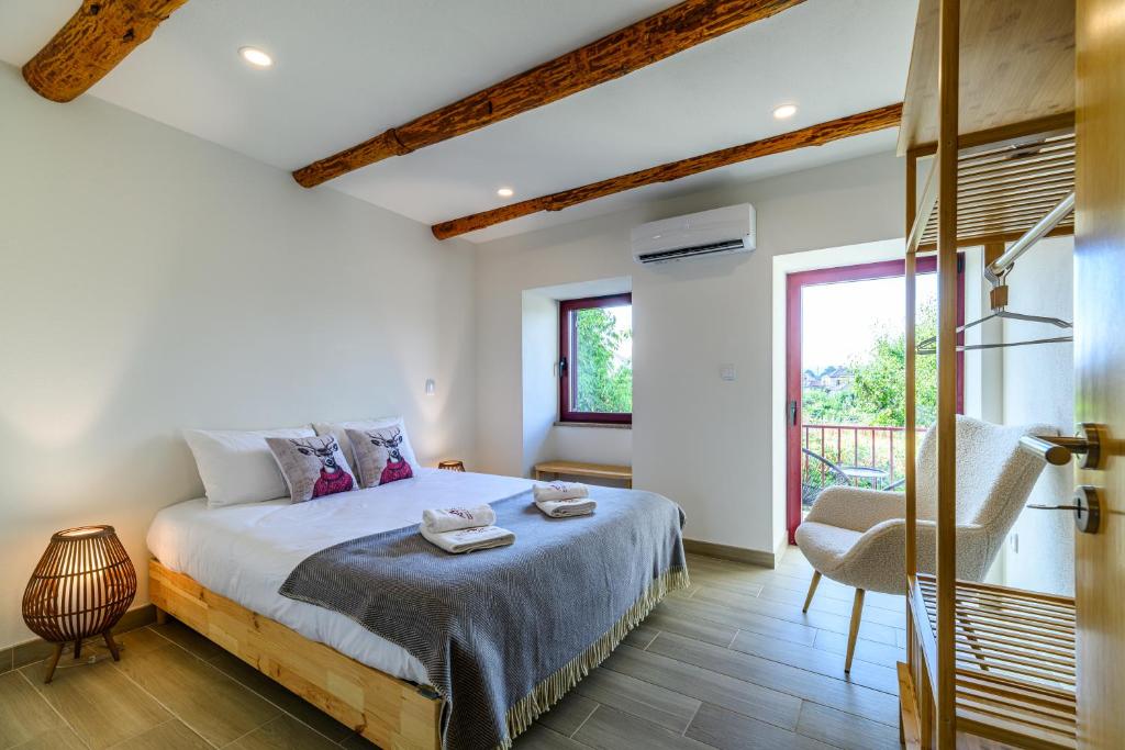 a bedroom with a bed and a chair and a window at Tréguas D'Inverno I in Seia