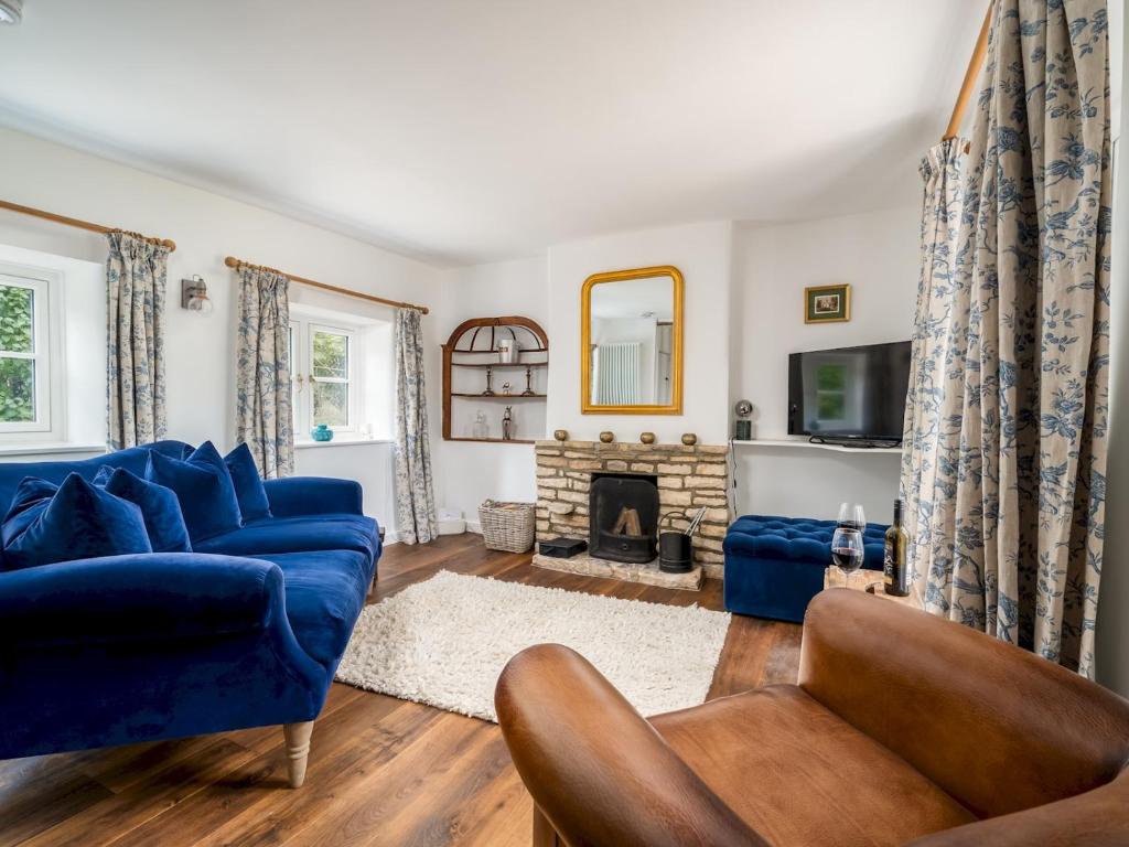 a living room with a blue couch and a fireplace at Pass the Keys Cotswold Country Style Living Chipping Norton in Chipping Norton