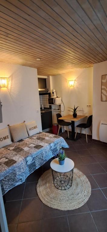 une chambre avec un lit et une table dans une pièce dans l'établissement Appartement 1 personne centre ville, au Puy-en-Velay