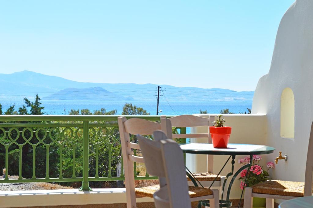 balcón con mesa, sillas y vistas al océano en Kalia Studios, en Agia Anna de Naxos