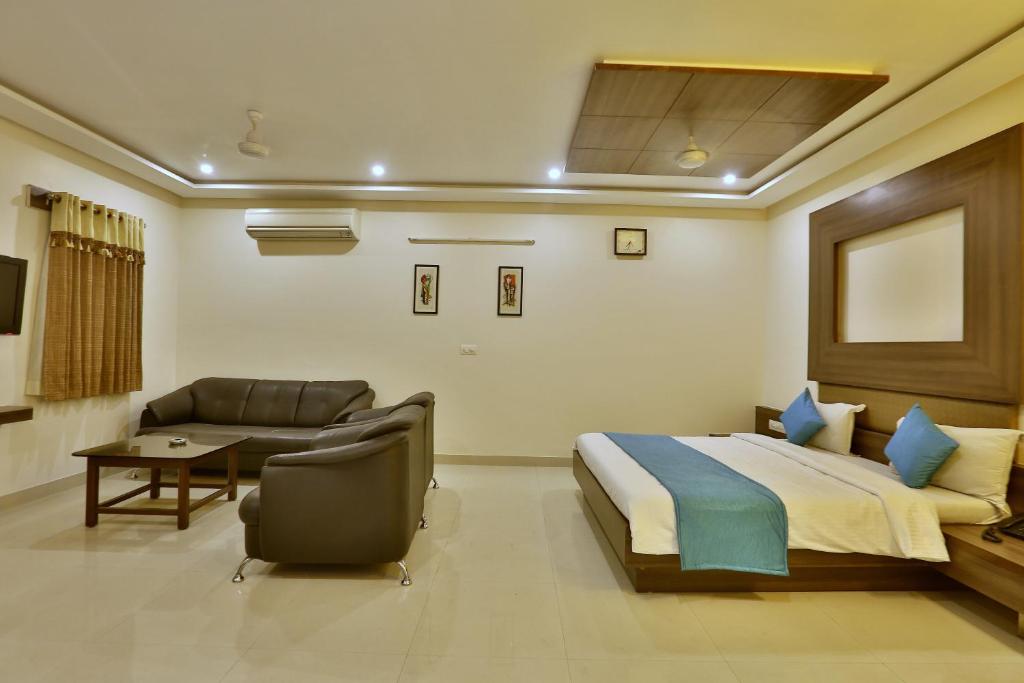 a hotel room with a bed and a couch at Hotel Kamran Palace in Ahmedabad