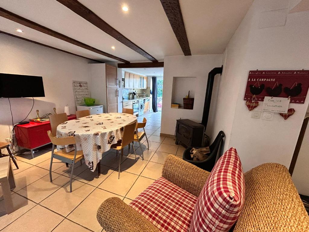 a living room with a dining room table and chairs at Petit coin de bonheur - 3 chambres & 1 poele à bois in Hultehouse