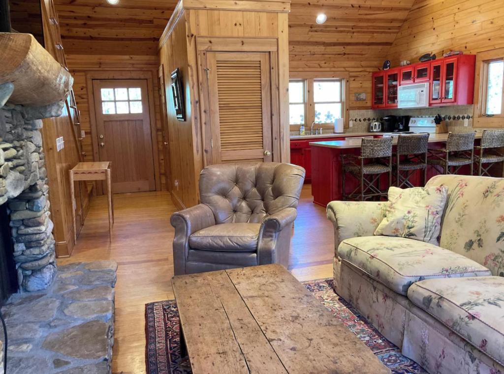 una sala de estar con sofá y sillas en una cabaña en Ruby Cabin at Splendor Mountain, en Tiger