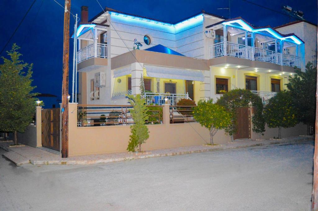 a large white house with blue lights on it at Villa Emmanouela Studios - Family Accommodation in Nea Vrasna