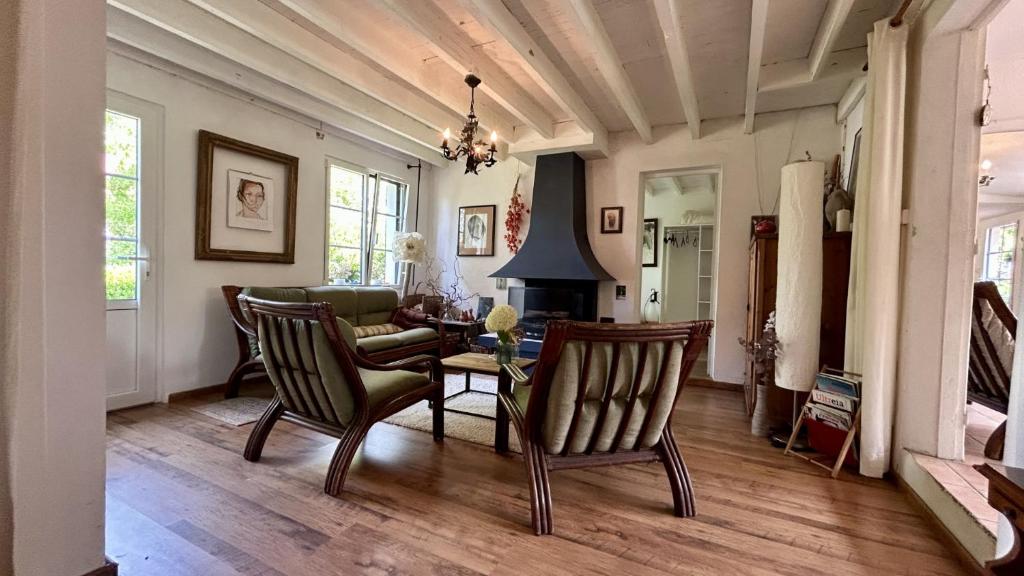 un soggiorno con un divano, un tavolo e delle sedie di Maison de Campagne Authentique – Havre de Paix pour Âmes Sensibles a Bernay-en-Ponthieu