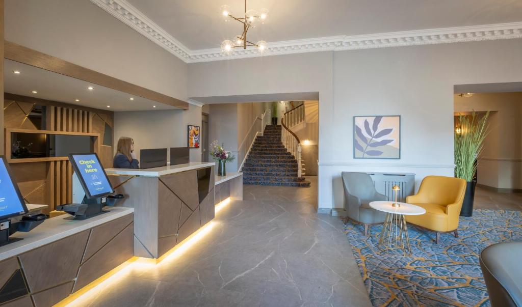 a hotel lobby with a reception desk and a staircase at Maldron Hotel Shandon Cork City in Cork