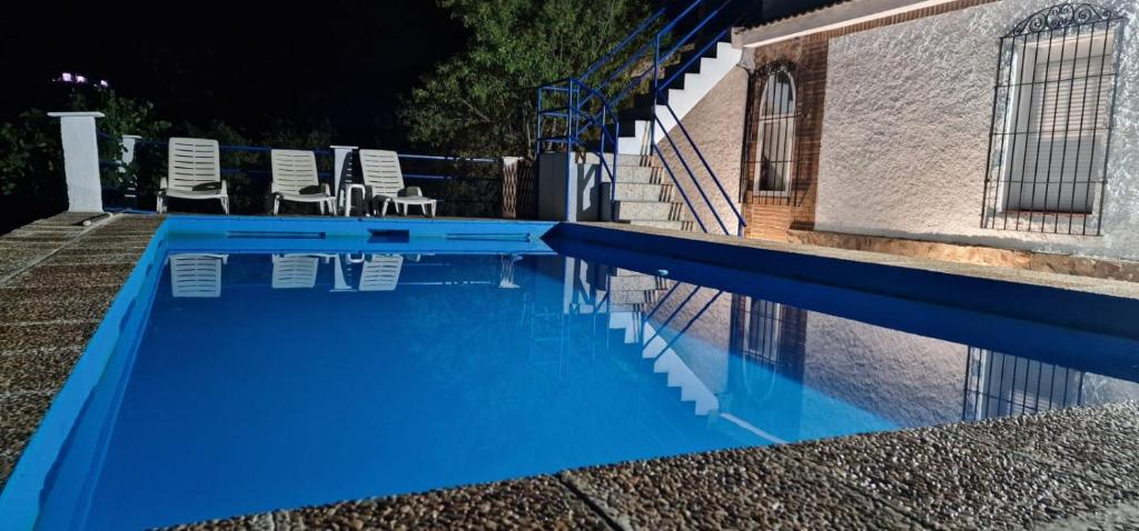 una piscina blu con sedie e un edificio di Villa Josefina a Puerto Lápice