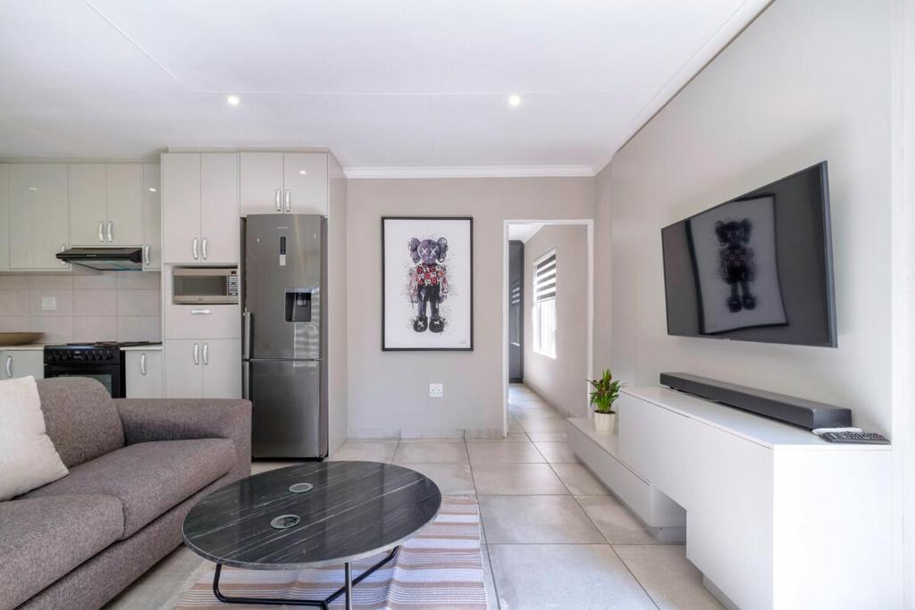 ein Wohnzimmer mit Sofa und Tisch in der Unterkunft #AlimamaSpaces Culross Cottage Retreat in Johannesburg