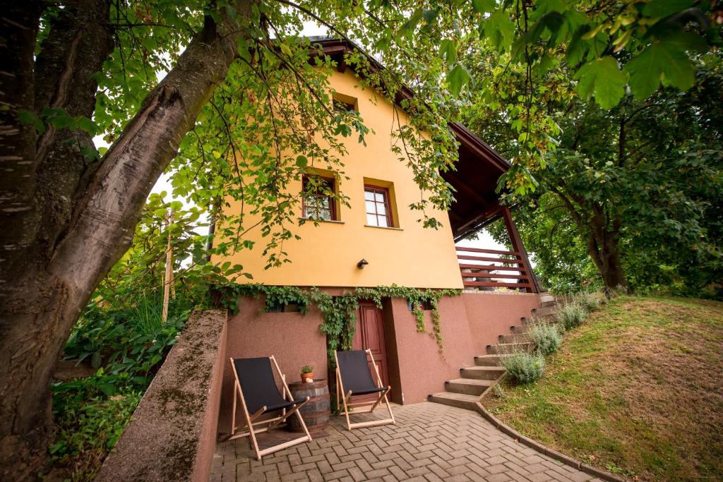 a house with two chairs in front of it at Počitniška hiša Car in Dobrovnik