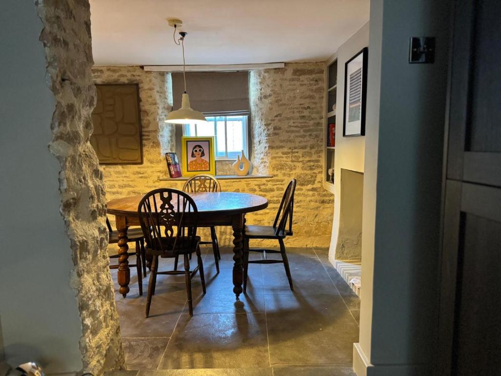 eine Küche und ein Esszimmer mit Tisch und Stühlen in der Unterkunft Well Cottage, Thames St in Charlbury
