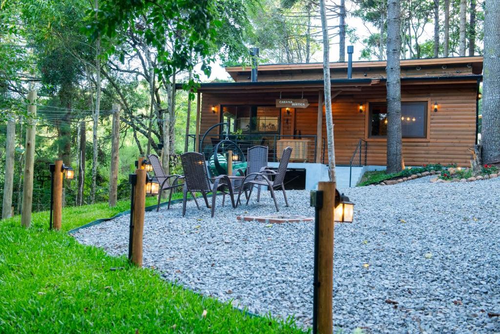 a house with a table and chairs in front of it at Cabana Rústica em Gramado in Gramado