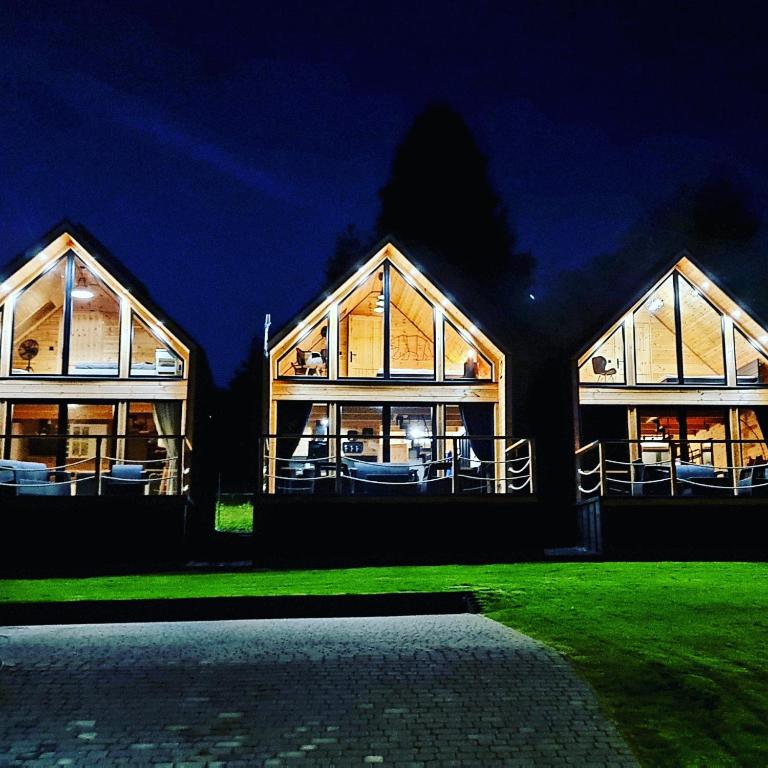a large house with glass windows at night at Domki Pod Cerkwią in Komańcza