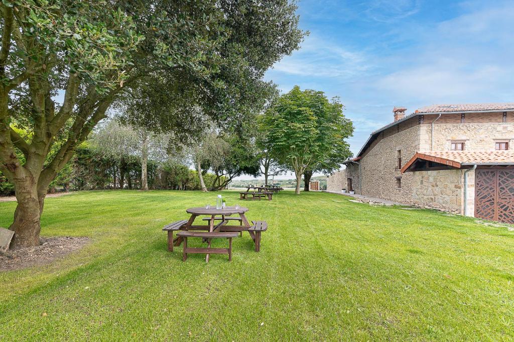 a picnic table in the grass next to a building at Infinity Coast by Fidalsa in Miengo