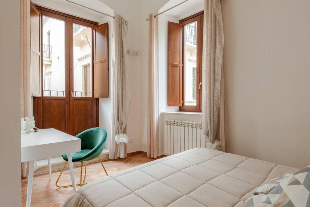 a bedroom with a bed and a desk and window at La Dimora del Fattore in LʼAquila