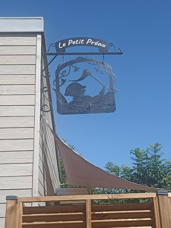 a sign on the side of a house with a hammock at Le petit Préau 10 min plages in Coudeville