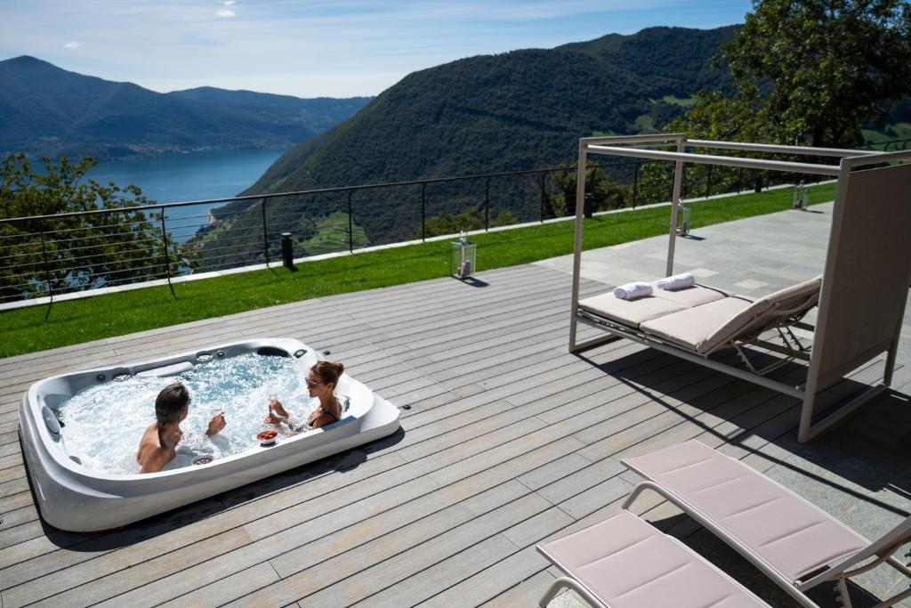 a group of people in a hot tub on a deck at Villa Sebino Relais in Tavernola Bergamasca