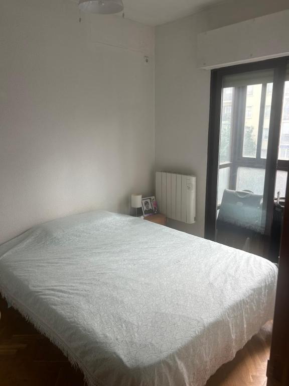 a white bed in a room with a window at Madrid Retiro Room in Madrid