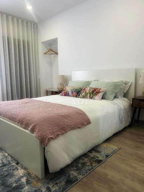 a bedroom with a large white bed with pillows at Cantinho D'Amy in Arcos de Valdevez