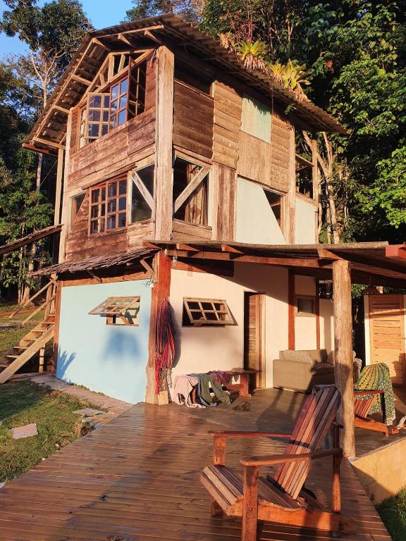 a wooden house with a porch and a deck at Casa Arco-Iris in Itacaré