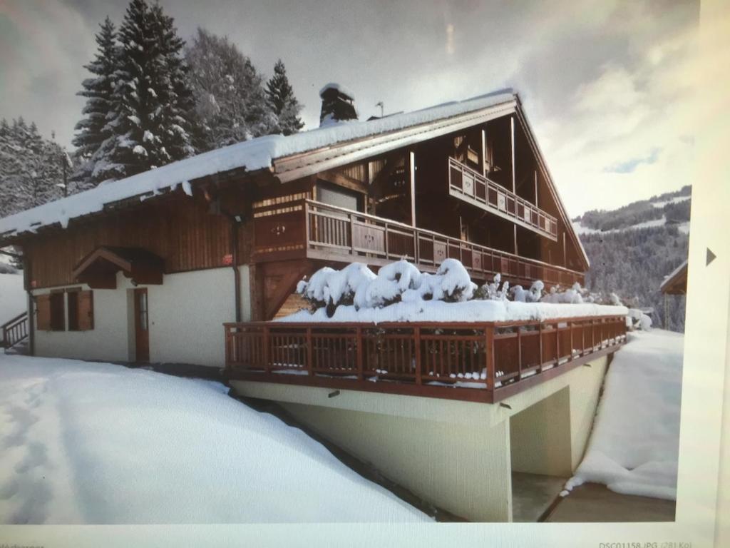 a house with snow on the roof of it at Appartement cosy avec jacuzzi privatif in Notre-Dame-de-Bellecombe