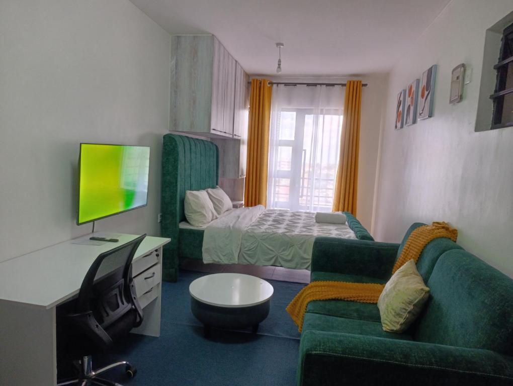 a room with a bed and a couch and a television at Luxe Studio Kinoo in Rungiri