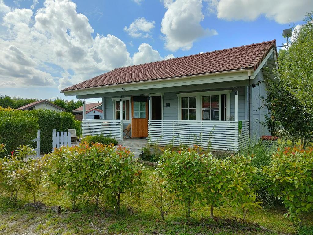 a small white house with a red roof at Le cottage des rives de l'Aa labélisé 3 étoiles in Bourbourg