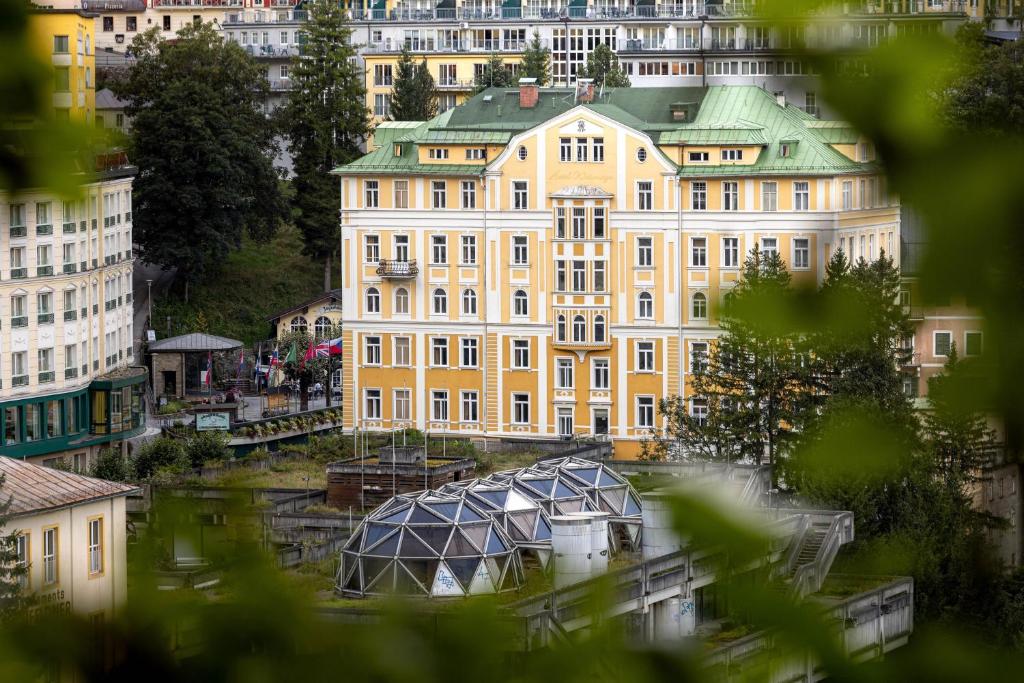 a large yellow building with a dome in front of it at the eighteen86 by keyone in Bad Gastein